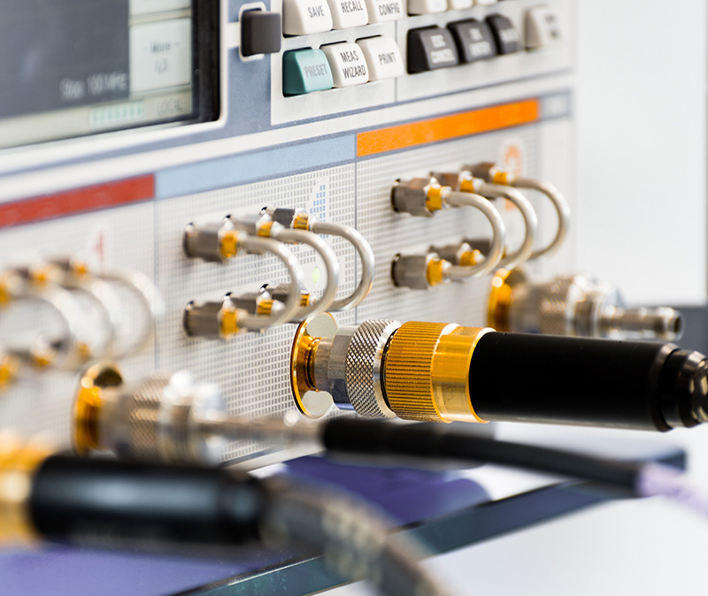 测试与测量 - 附有电缆和连接器的电子测试设备特写，控制面板上有各种刻度盘和按钮。